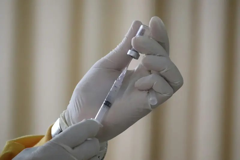 Gloved hands preparing a neuromodulator injection